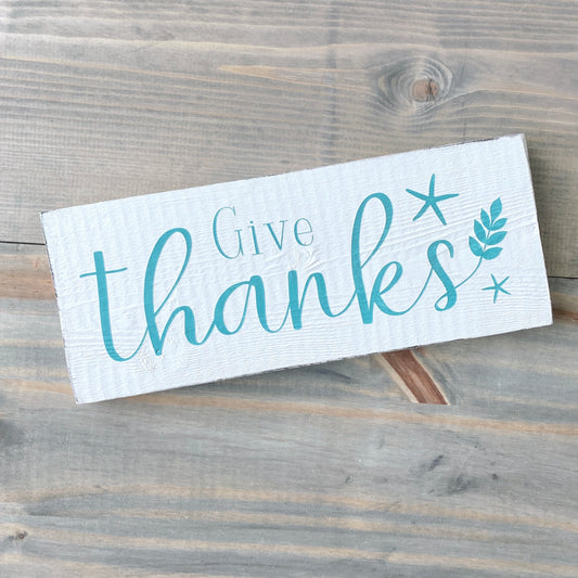 Wooden sign with 'Give thanks' text on a wooden background
