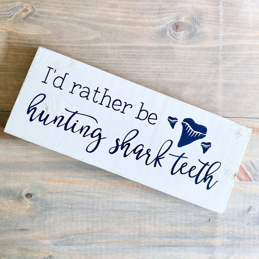 Coastal Wooden sign with text 'I'd rather be hunting shark teeth' on a wooden surface