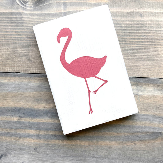 pink flamingo design on a white background and wooden surface