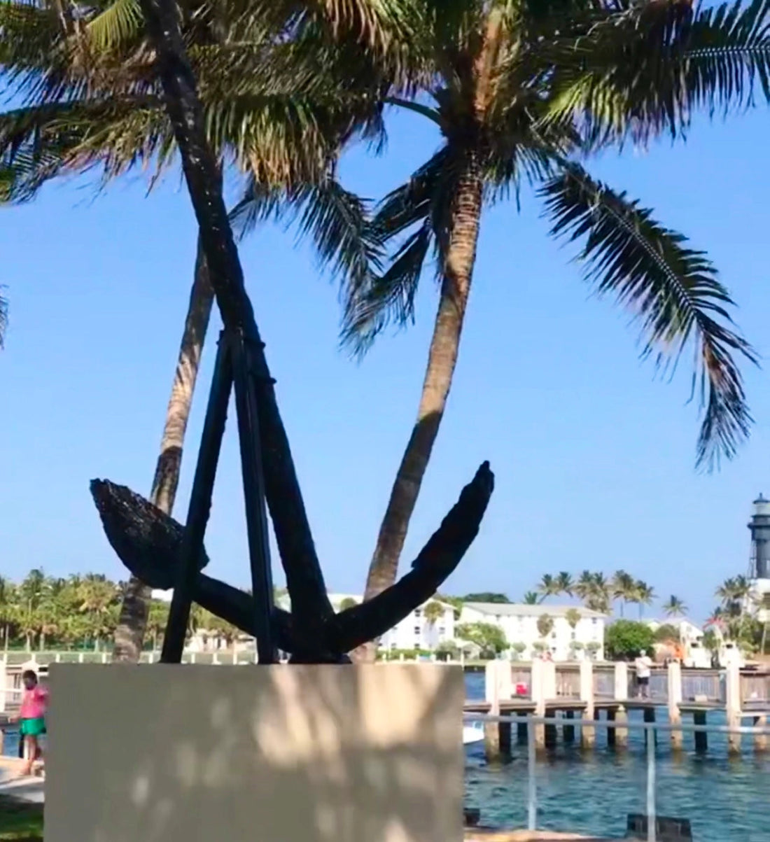 Anchor display with boat marina background. Moving to the beach