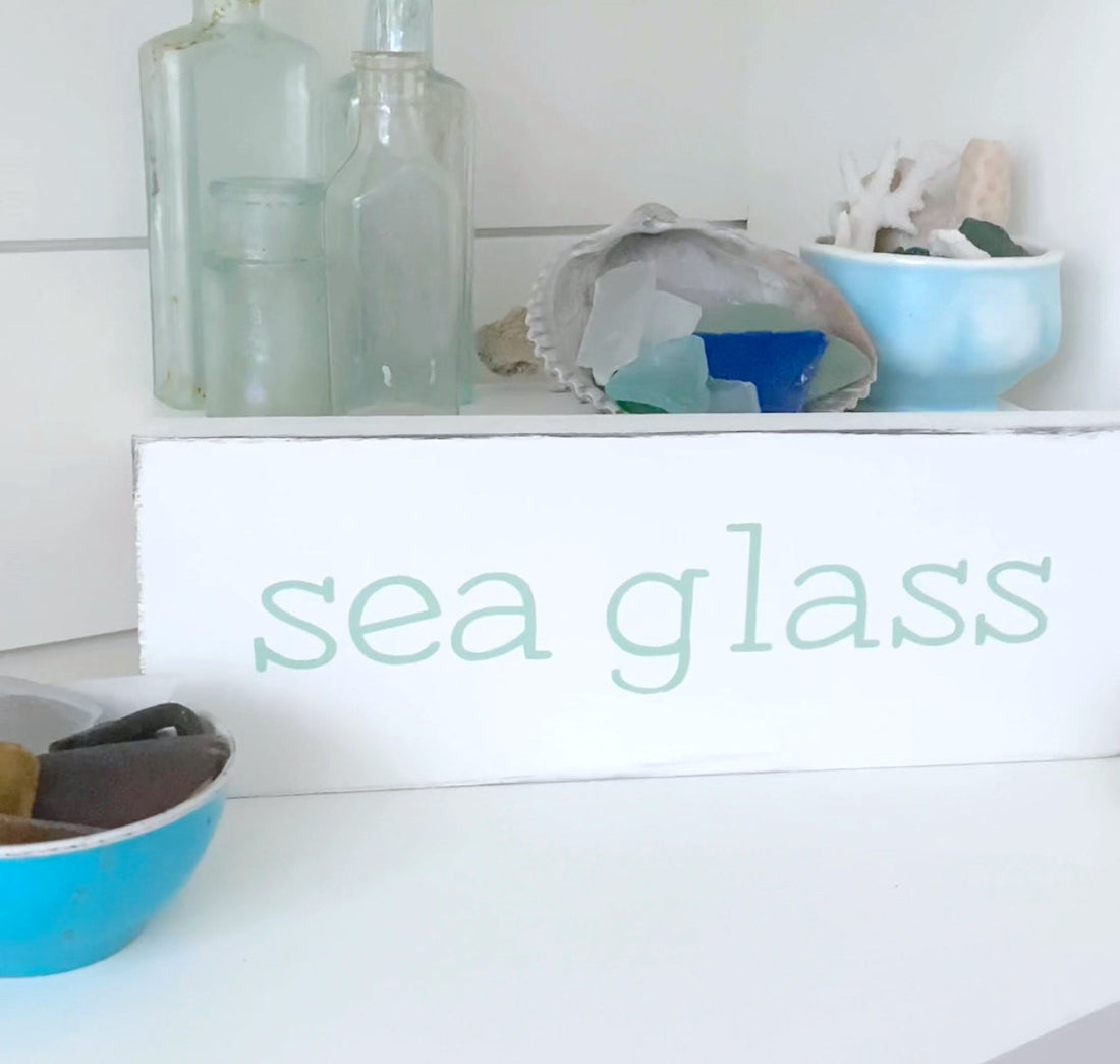 Sea glass collection displayed with handmade coastal signs and beach decor on Amelia Island