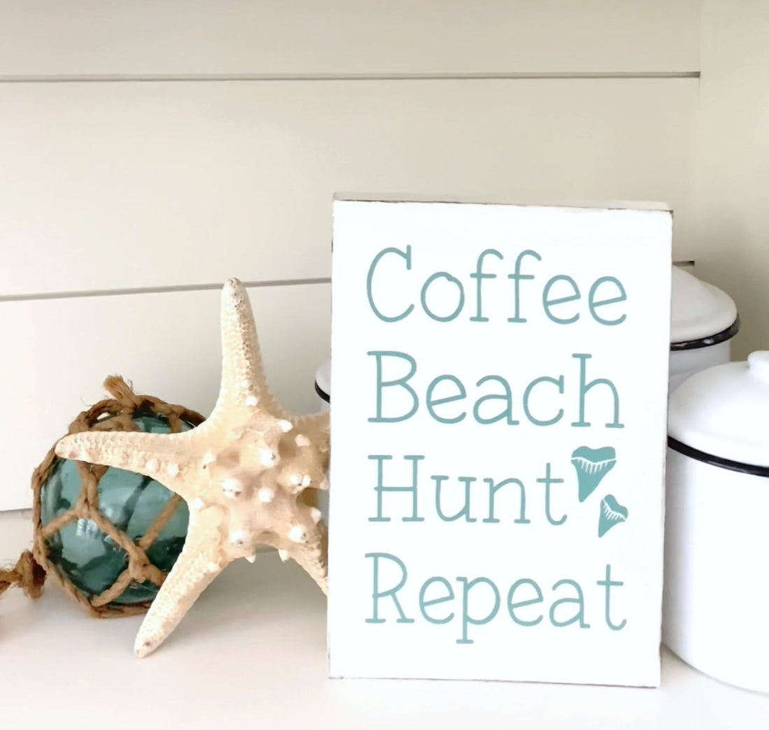 Handmade beachcombing signs displayed with sea glass, shells, and coastal decor from Anchored Soul Designs