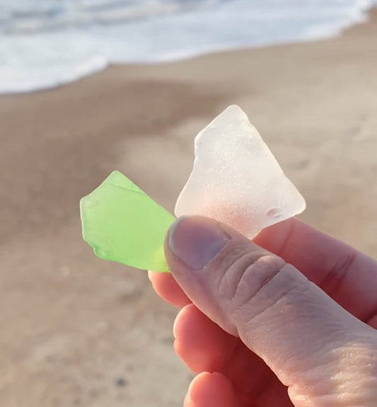 Frosted sea glass pieces collected on a beach, perfect for beachcombing and coastal decor displays