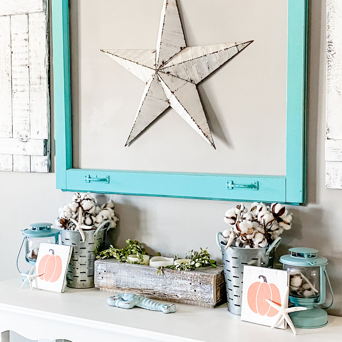 Coastal fall entryway decor featuring handmade Pumpkin Signs styled on a mantel with cotton stems, starfish, aqua lanterns, a rustic wood tray, and a distressed metal star on a turquoise frame, beach house fall decorations made on Amelia Island Florida