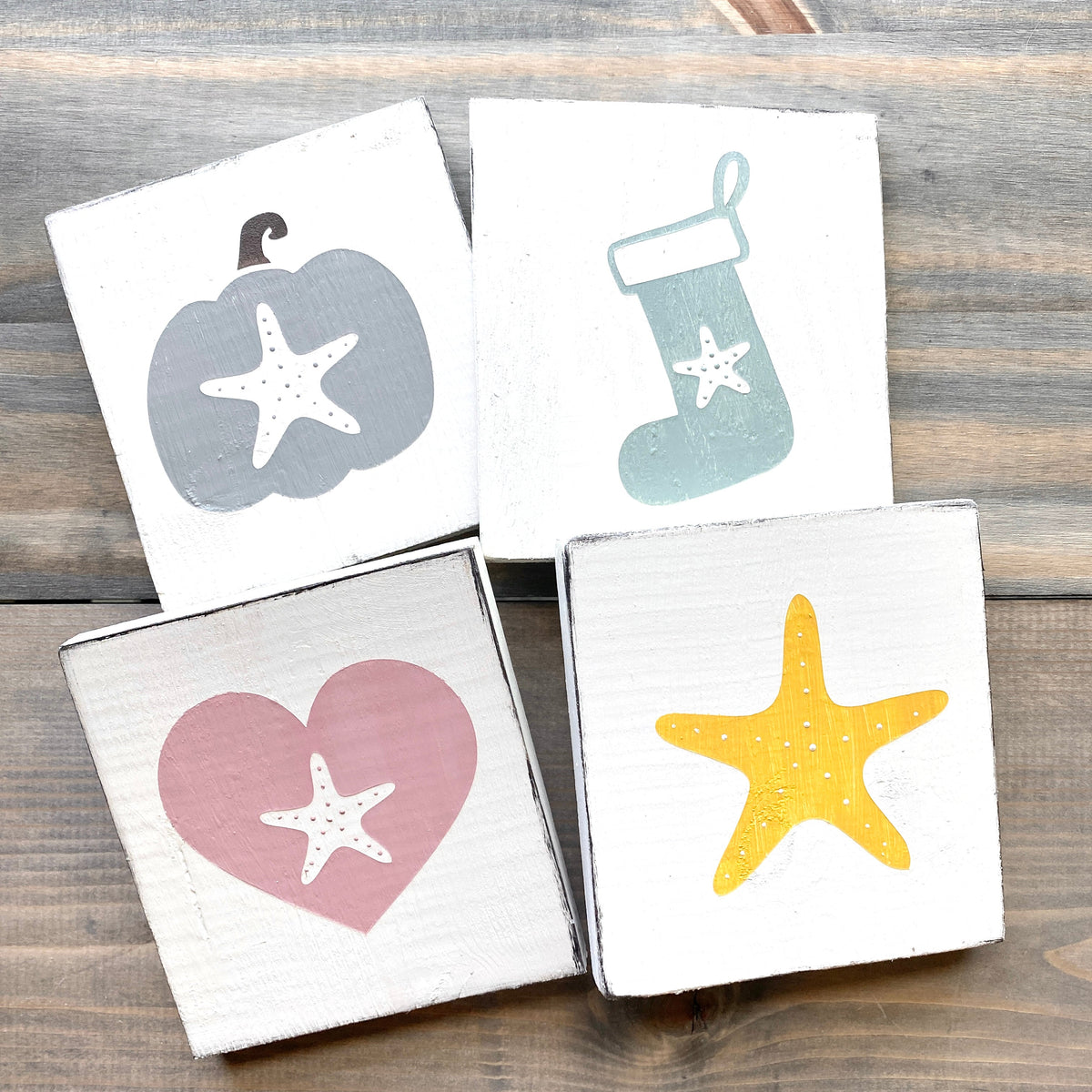 Handcrafted coastal wood signs featuring a starfish pumpkin, starfish Christmas stocking, starfish heart, and starfish sign representing fall, Christmas, Valentine's Day, and everyday sea creature decor