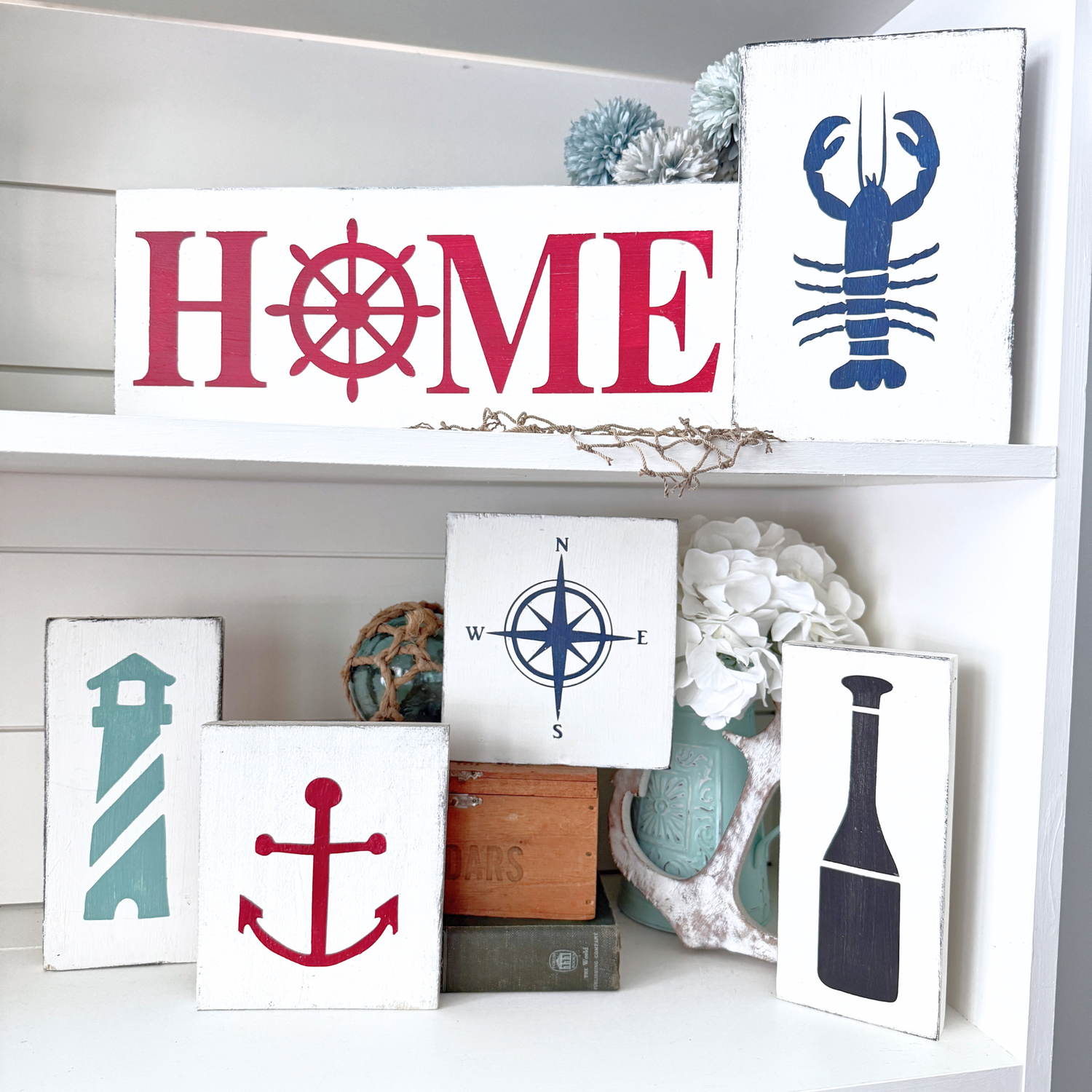 Handmade nautical signs displayed on a shelf, coastal home decor by Anchored Soul Designs