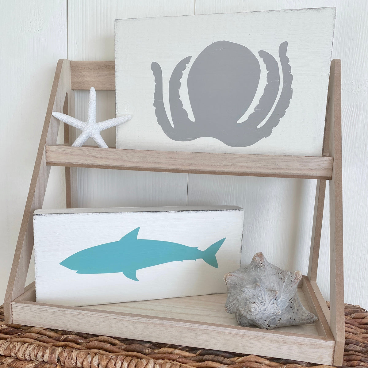 Handcrafted octopus and shark coastal signs displayed on a two-tier wooden tray with starfish and shell accents