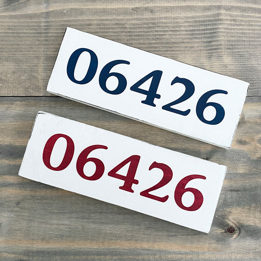 Two rectangular signs with the number '06426' on a wooden surface.