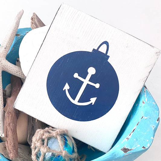 Decorative item with a blue circle and white anchor symbol on a white background