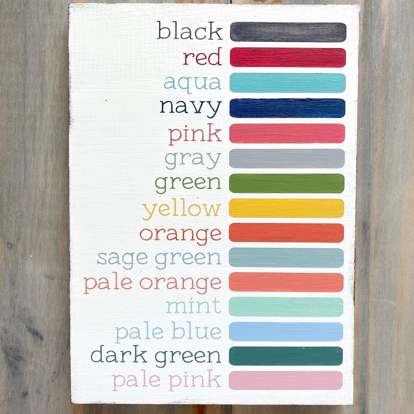 Anchored Soul color Display Photo with wood sign showing all available colors painted in words and color block - black, red, aqua, navy, pink, gray, green, yellow, orange, sage green, pale orange, mint, pale blue, dark green, pale pink