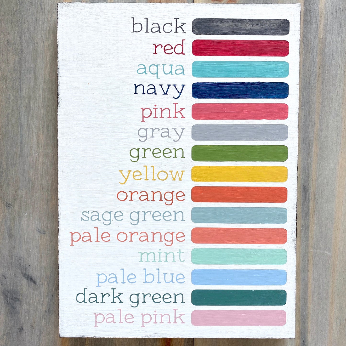 Anchored Soul color Display Photo with wood sign showing all available colors painted in words and color block - black, red, aqua, navy, pink, gray, green, yellow, orange, sage green, pale orange, mint, pale blue, dark green, pale pink