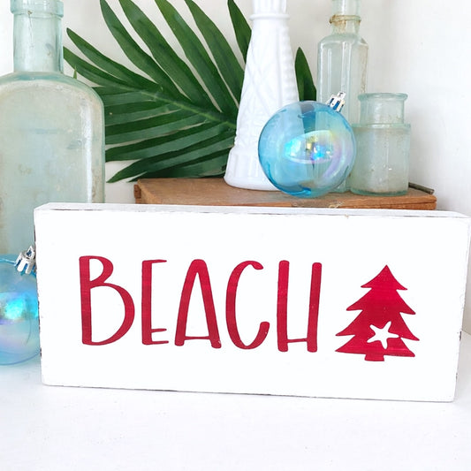 Decorative sign with 'BEACH' and a tree illustration, surrounded by decorative items.