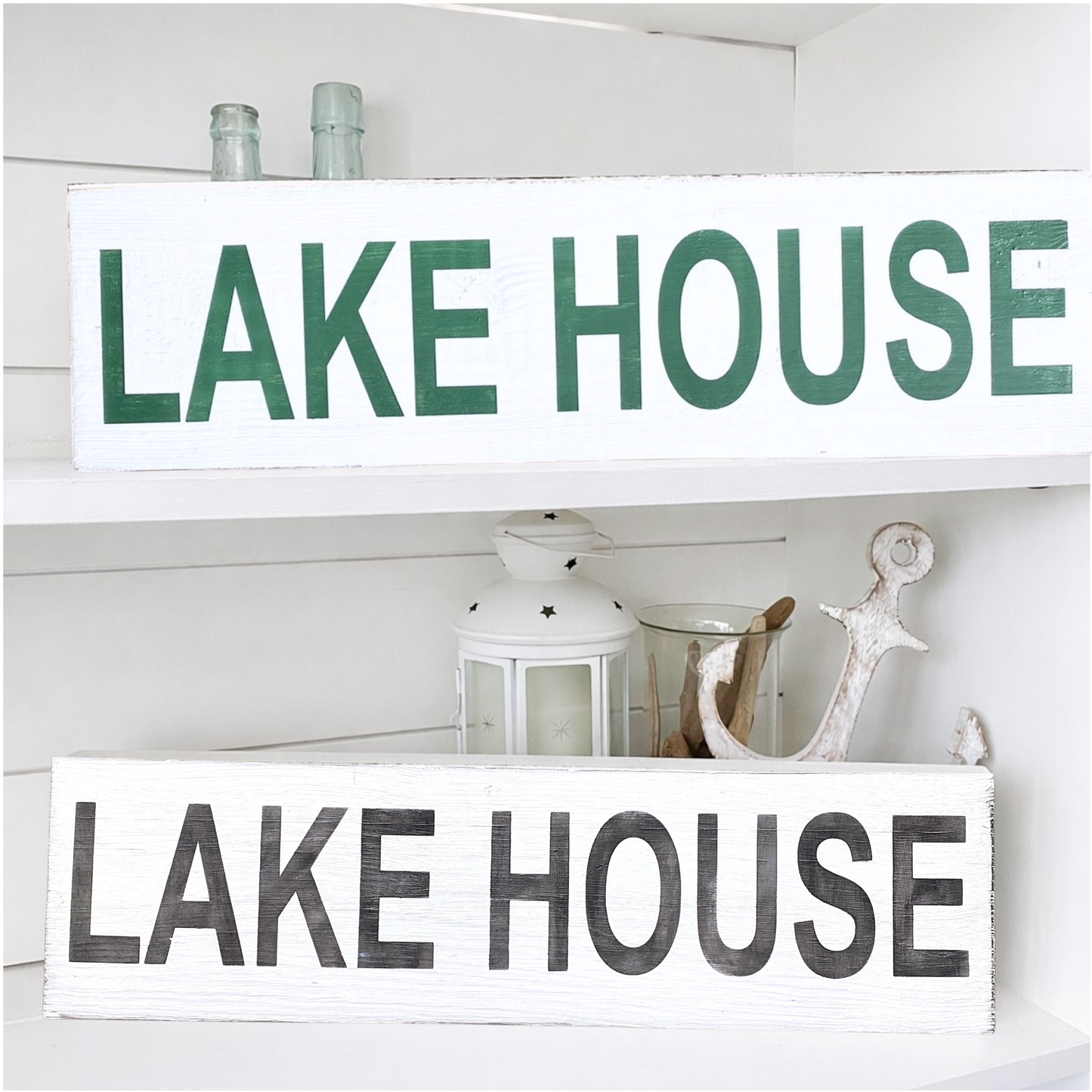 Two lake house signs on a shelf with other nautical decor