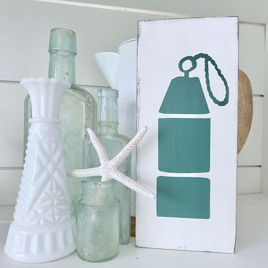 Decorative shelf with bottles, a starfish, and a sign with an oar design.