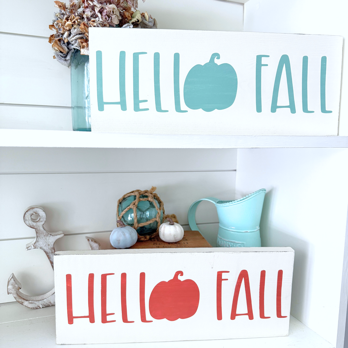 Decorative signs with 'Hello Fall' text and pumpkin graphics on a white surface.