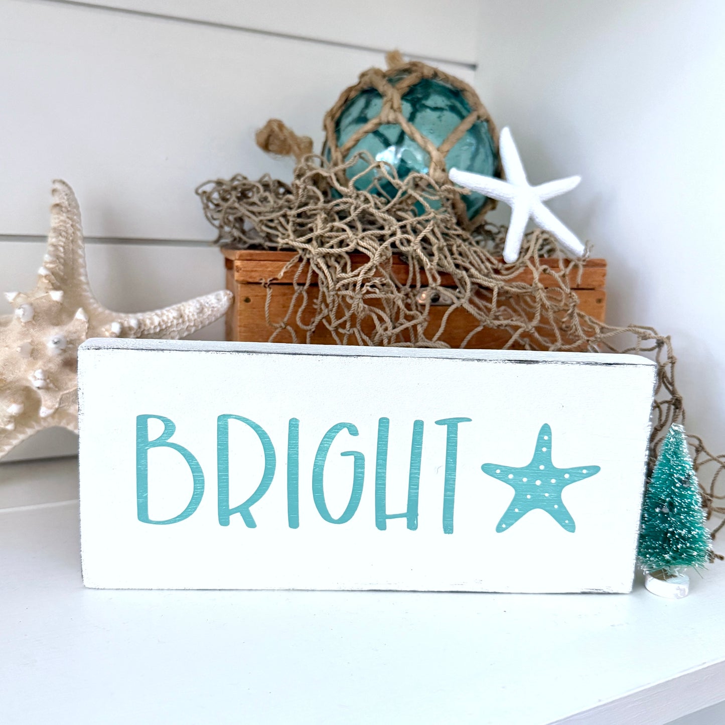 Decorative sign with 'BRIGHT' and starfish design, surrounded by nautical-themed decor.