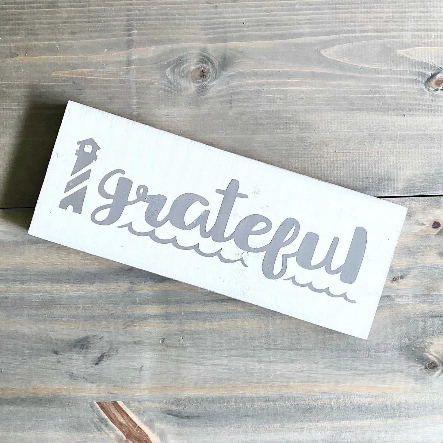 White signl with 'grateful' text on a wooden surface