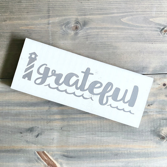 White signl with 'grateful' text on a wooden surface