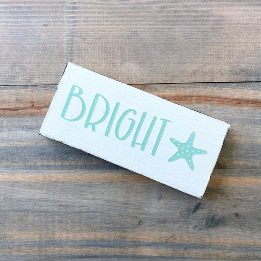 Wooden sign with 'BRIGHT' and a starfish on a wooden surface