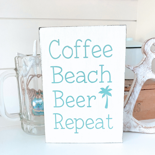 Sign with 'Coffee Beach Beer Repeat' text on a white background