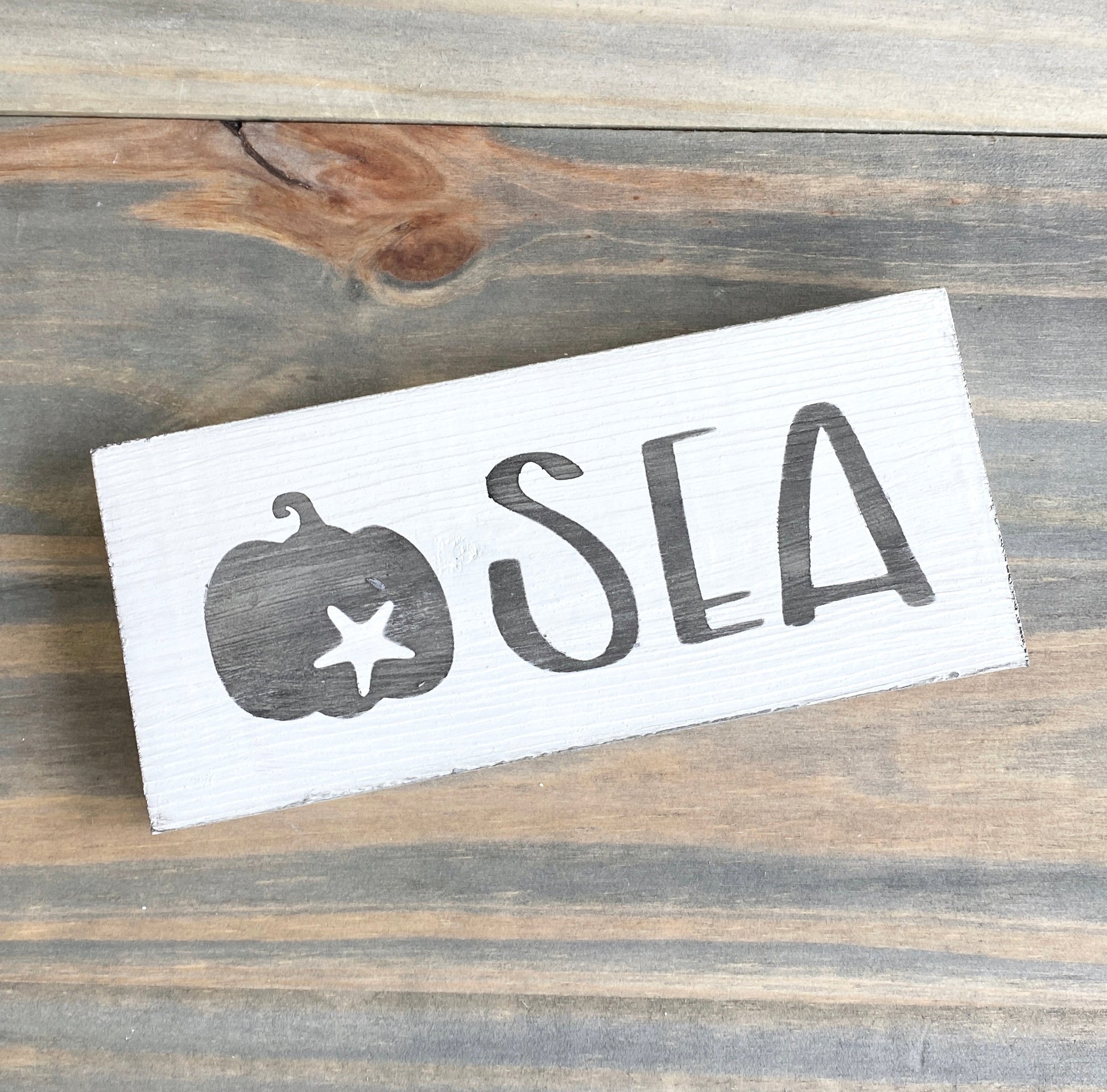 black pumpkin with starfish sea sign, fall by the sea, coastal fall, fall beach decor