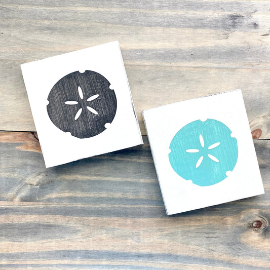 Sand dollar beach sign on wood in black and aqua with white background
