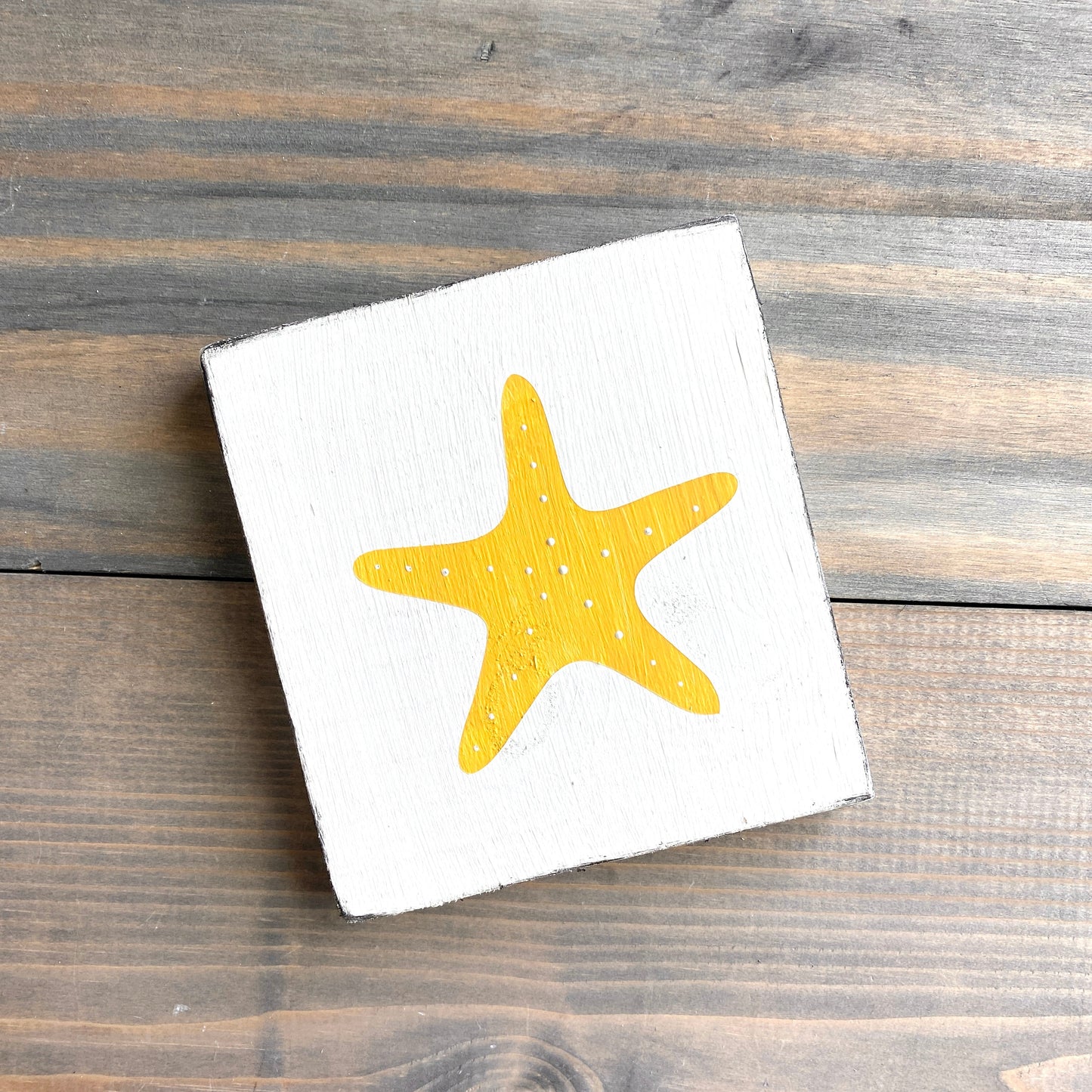 Starfish beach sign on real wood, coastal decor displayed in yellow