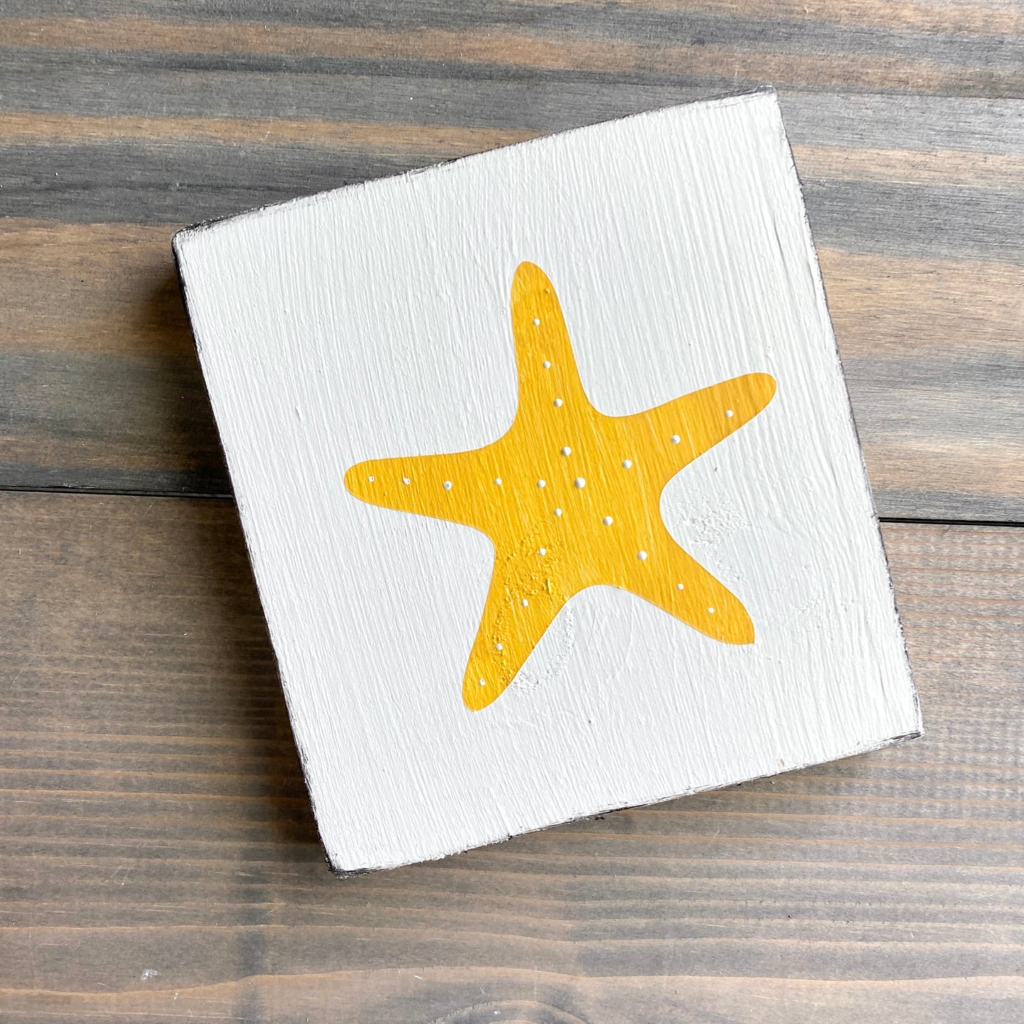 Starfish beach sign on real wood, coastal decor displayed in yellow