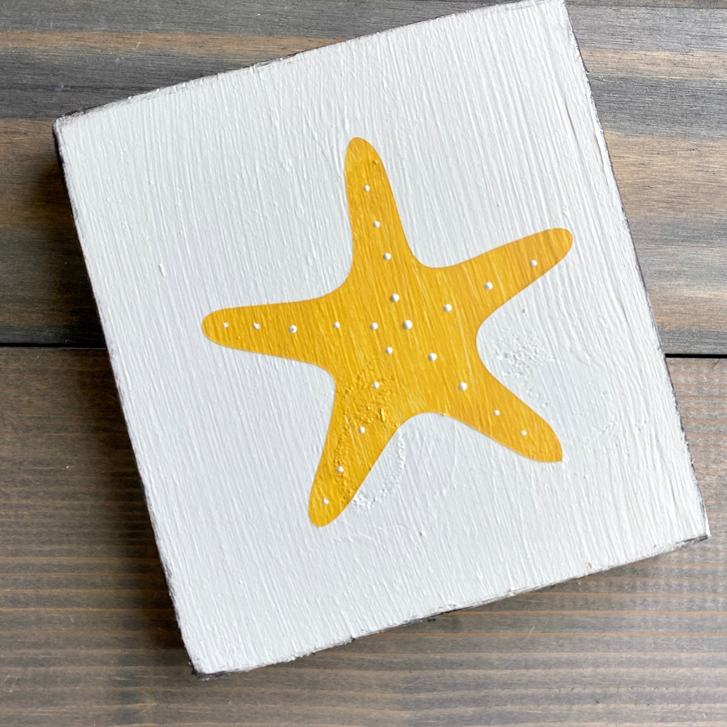 Starfish beach sign on real wood, coastal decor displayed in yellow